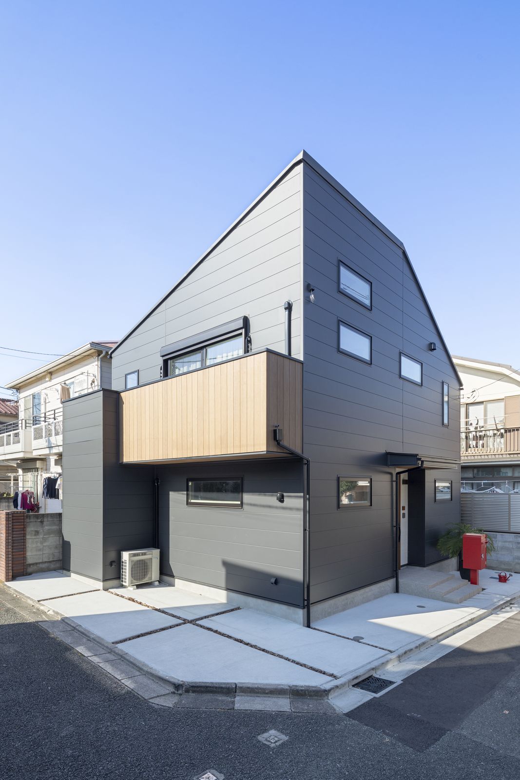 黒いガルバリウムとバルコニーの木目がおしゃれな外観デザイン。東南向きの角地のため、自然光がたっぷり入りこむように、駐車スペースも2台分確保しています。