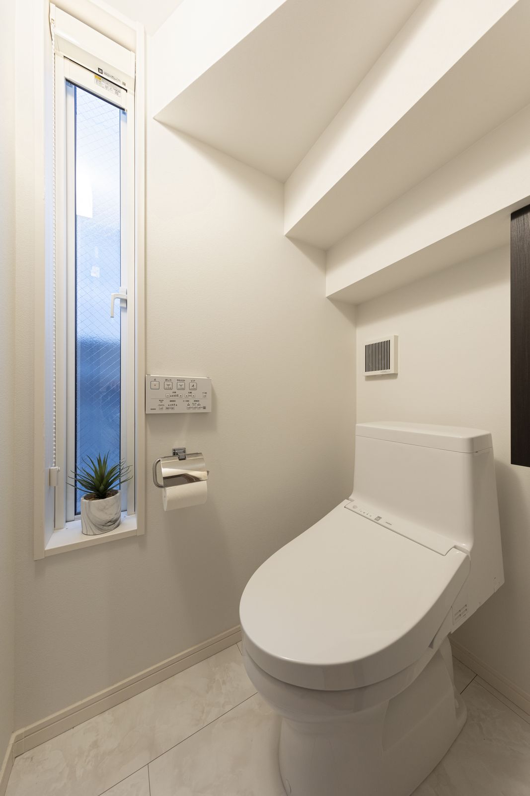 階段の下に設置した1階トイレ。ホテルにあるようなおしゃれなトイレットペーパーホルダー。